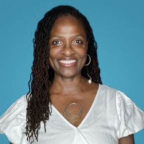 Woman smiling with locks against a blue background. 